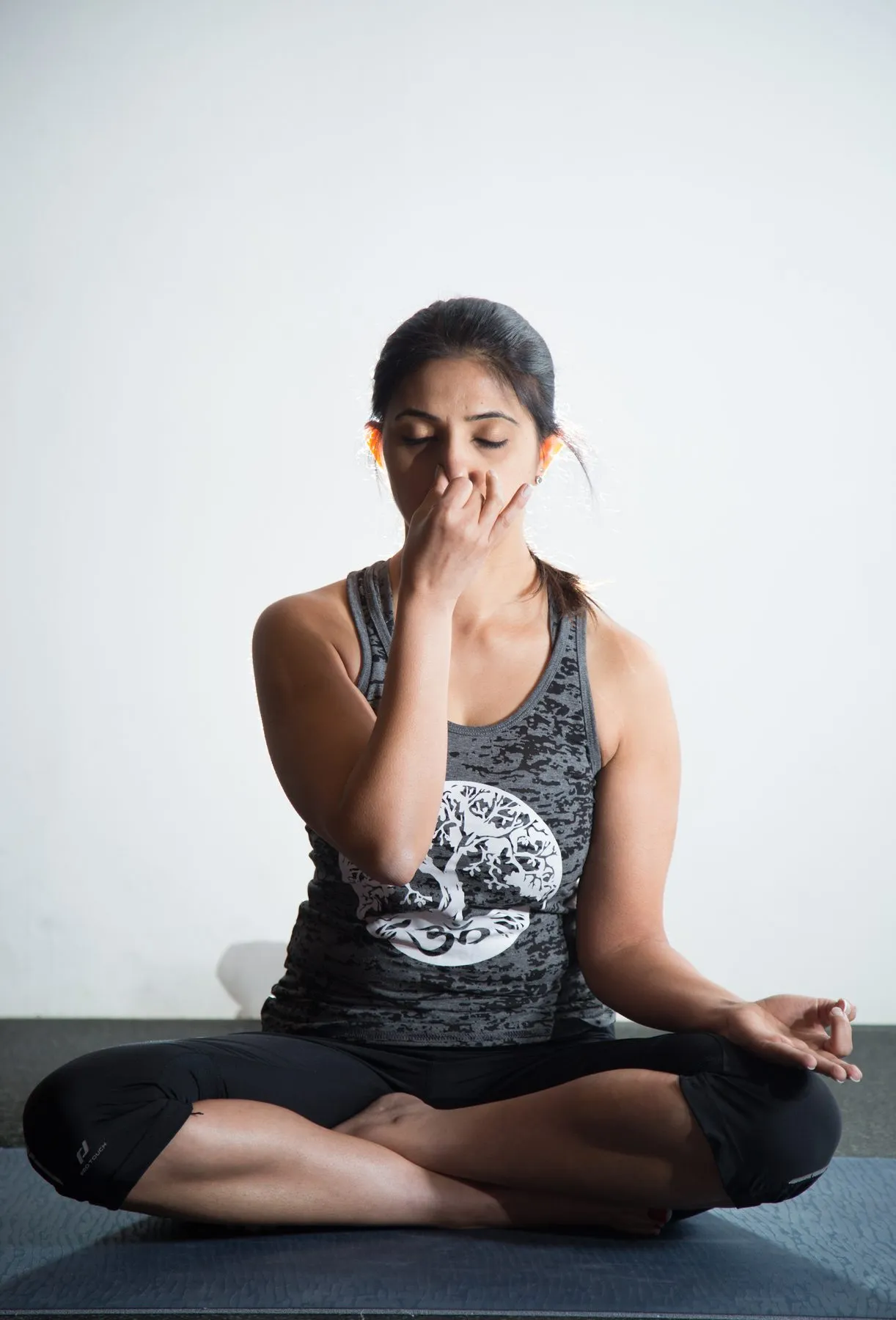 Seated cross-legged, practising alternate nostril breathing